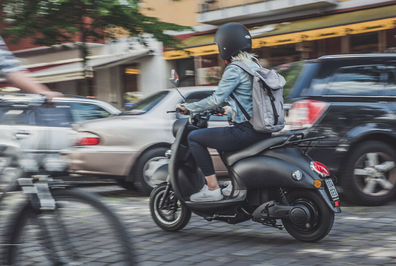Wendig schlängelt man sich auf dem kleinen Elektroroller durch den Stadtverkehr