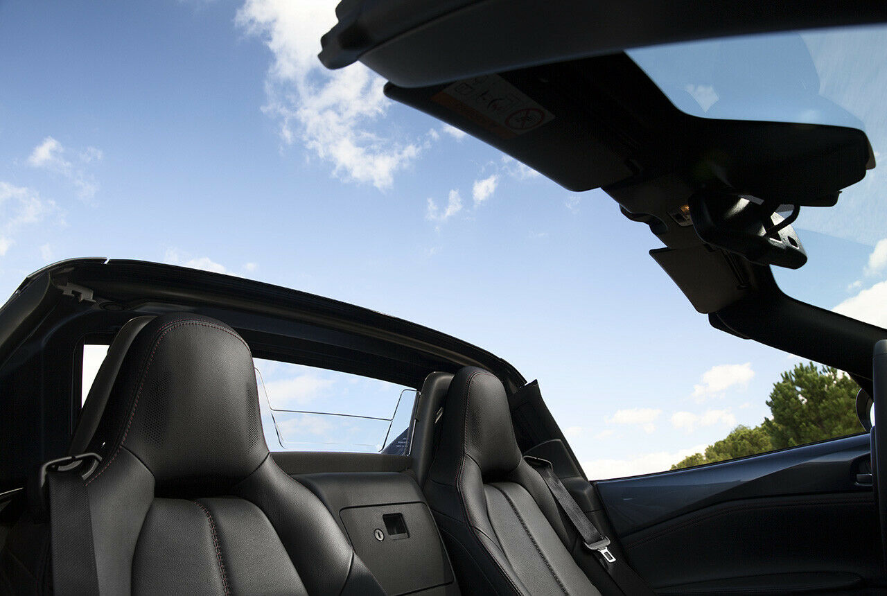 Das einzige "Handschuhfach" ist bei der Fahrt kaum zu erreichen.Die Lautsprecher in den Kopfstützen gehören zur Bose-Soundanlage, serienmäßig in der höchsten Ausstattung