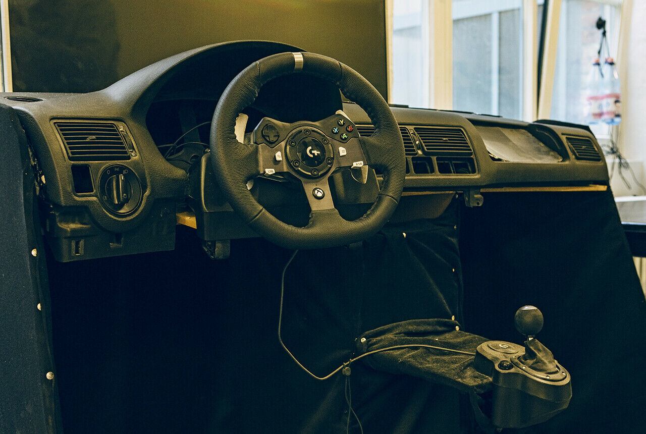 Für die ersten Praxistests diente das Cockpit aus einem alten VW Golf als Dummy. Das Lenkrad ist ein Computerspiele-Steuer