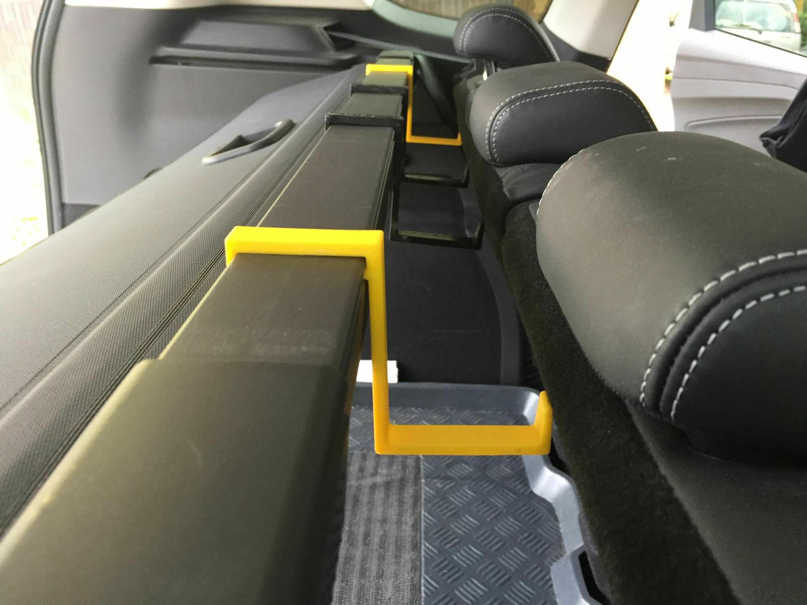 Regenschirmablage zwischen Rücksitzlehne und Kofferraum-Rollo