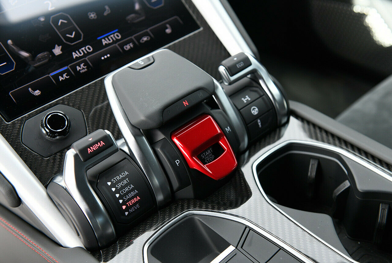 Bemüht um einen martialischen Eindruck versteckt sich der Start-Knopf im Lamborghini Urus unter einer roten Klappe. Nicht, dass man aus Versehen das Monster weckt