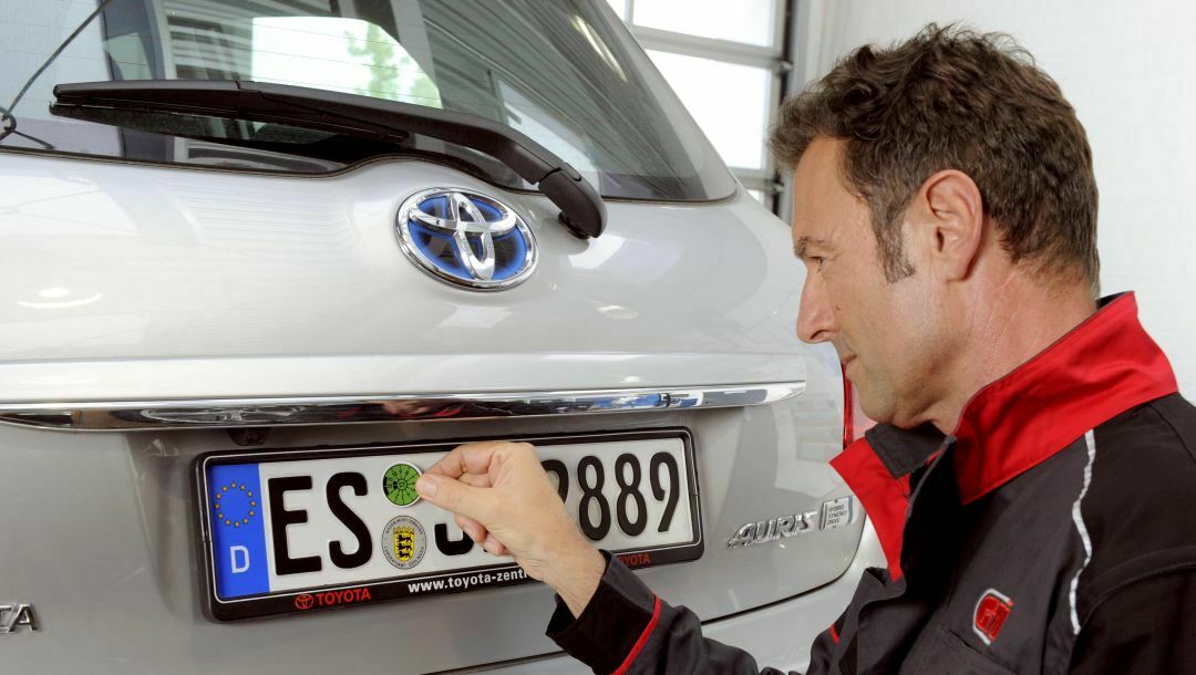 Ein GTÜ-Prüfer klebt die HU-Plakette. In Südhessen gab es Unregelmäßigkeiten.
