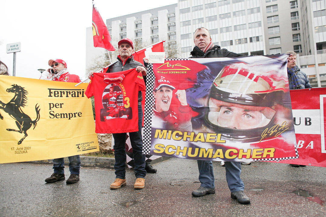 Fans schwenken Banner, Fahnen, Kappen und T-Shirts vor der Klinik in Grenoble