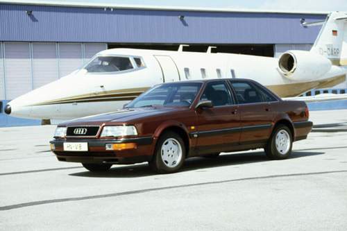 Statussymbole auf dem Prospektfoto: Audi V8 vor einem Learjet