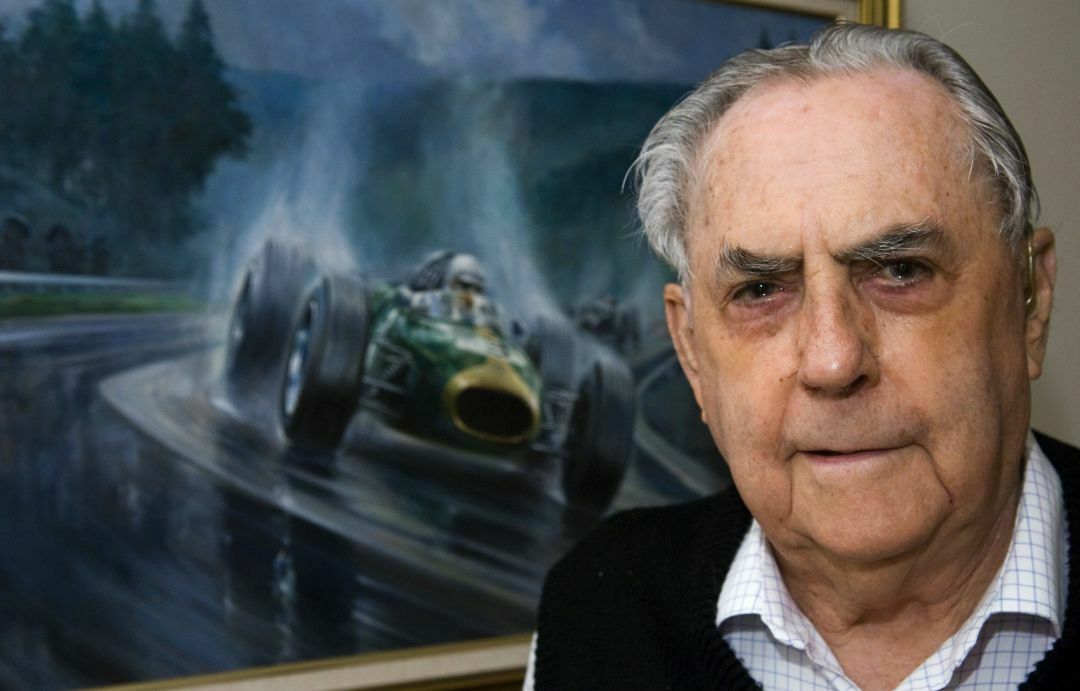 Jack Brabham posiert vor einem alten Foto in seinem Haus im australischen Gold Coast