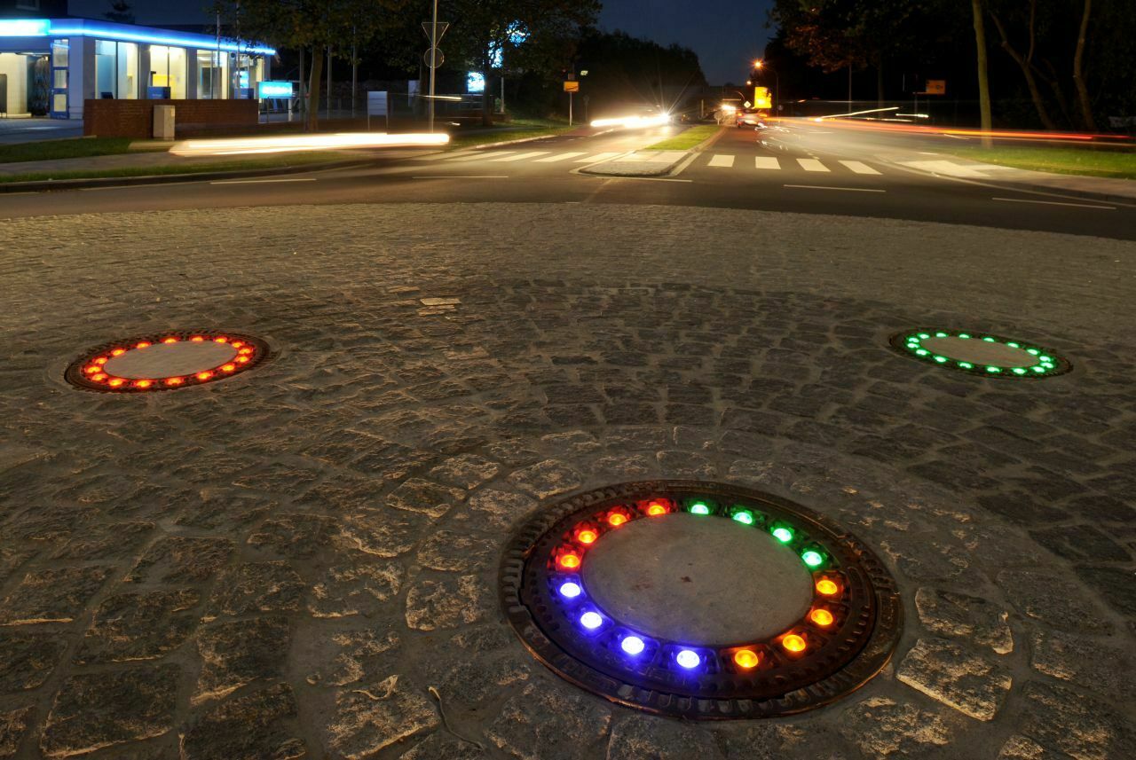 Darum geht es: Im Kreisverkehr stattete die Gemeinde fünf Gullideckel mit farbigen LED-Leuchten aus