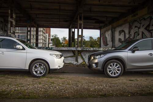 Radhausbeplankungen aus Plastik und geschwungene Kotflügel am Mazda gegen gerade Flanken am Mitsubishi