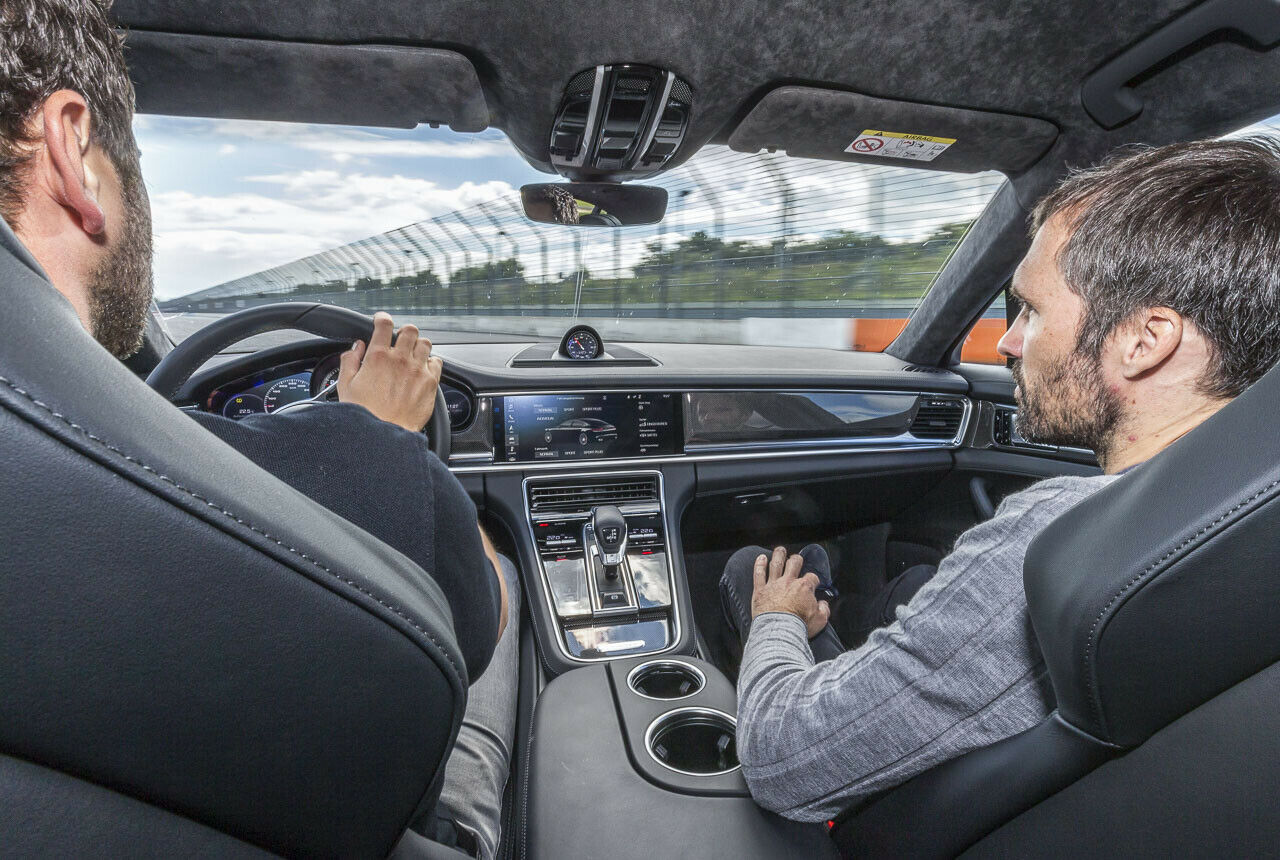 MOTOR-TALK-Redakteur Heiko Dilk lässt sich von Porsche-Entwicklungsfahrer Dominik Hartmann um den Kurs chauffieren
