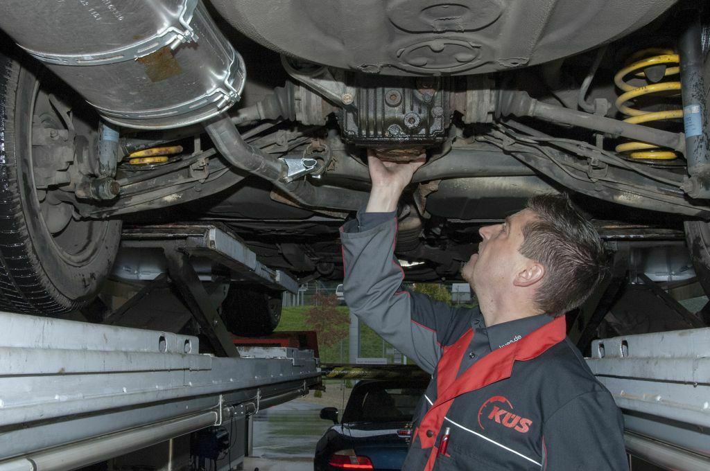 Ein Prüfer stellt fest, dass das Auto Öl verliert.
