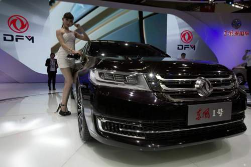 Auf der Automesse in Peking steht ein Model neben einem Auto von Dong Feng
