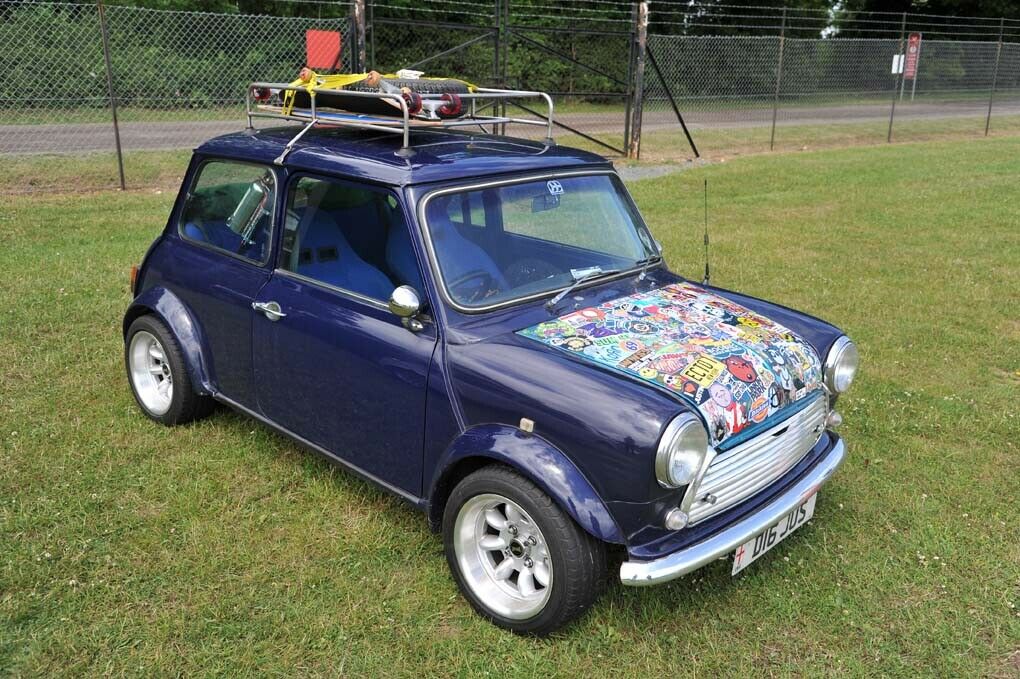 Ein Mini mit einem Longboard auf dem Dach