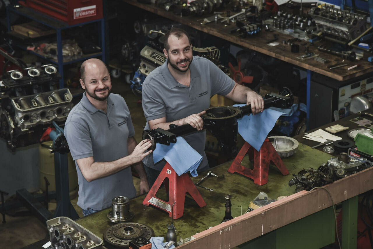 Hans-Gerd Brauneiser (li) und Thomas Uhles schrauben schon seit fast 20 Jahren zusammen. In der Halle liegen Motoren und Getriebe herum, auf der langen Werkbank stehen Ventile und Nockenwellen. Was unaufgeräumt wirkt, hat System