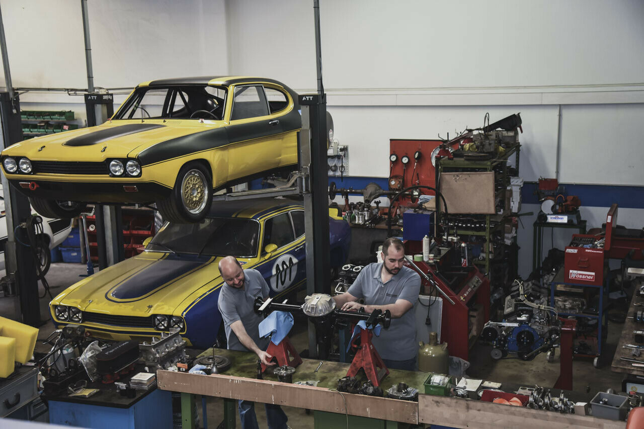 Hans-Gerd Brauneiser (li) und Thomas Uhles bearbeiten in ihrer Werkstatt meist Ford-Rennwagen, wie diese beiden Capri und die dazu passende Hinterachse