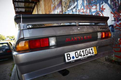 Ein größerer Spoiler, eine breitere Schürze und eine schwarze Plastik-Blende mit Schriftzug am Exclusiv-Manta