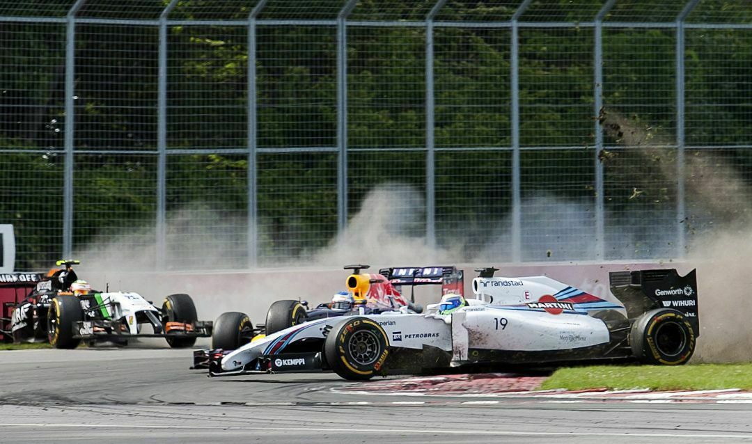Sebastian Vettel fährt beim Großen Preis von Kanada zwischen den beiden verunglückten Formel-1-Autos von Massa und Perez durch