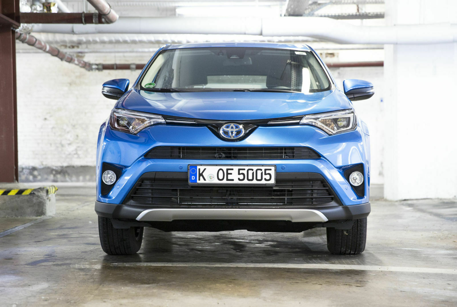 Den Hybrid erkennt man an der blauen Farbe im Toyota-Emblem, ansonsten ist er von vorn kaum vom Benziner zu unterscheiden
