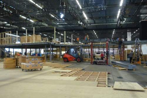 Ein neuer Boden wird in einer Messehalle verlegt
