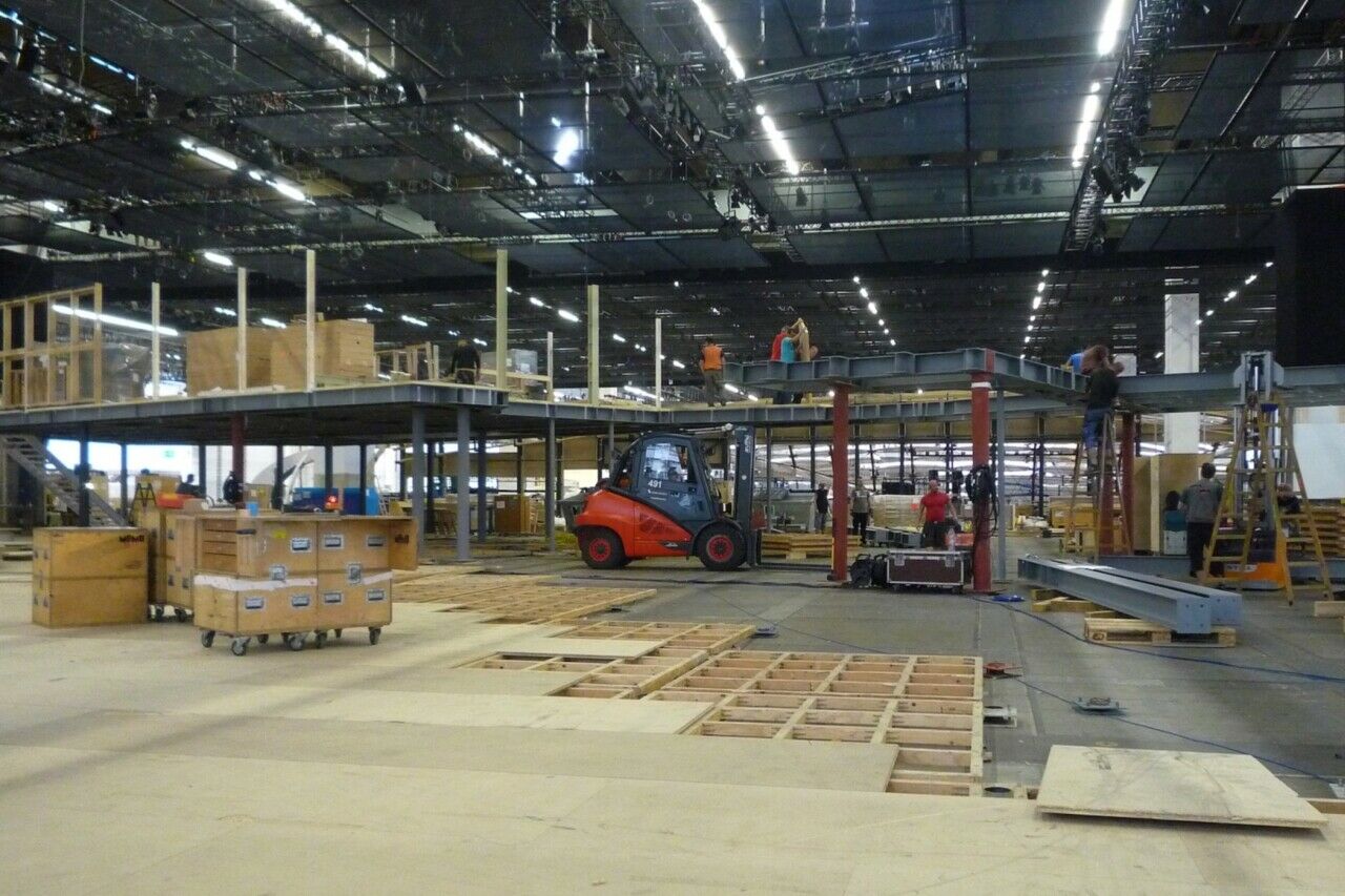 Ein neuer Boden wird in einer Messehalle verlegt
