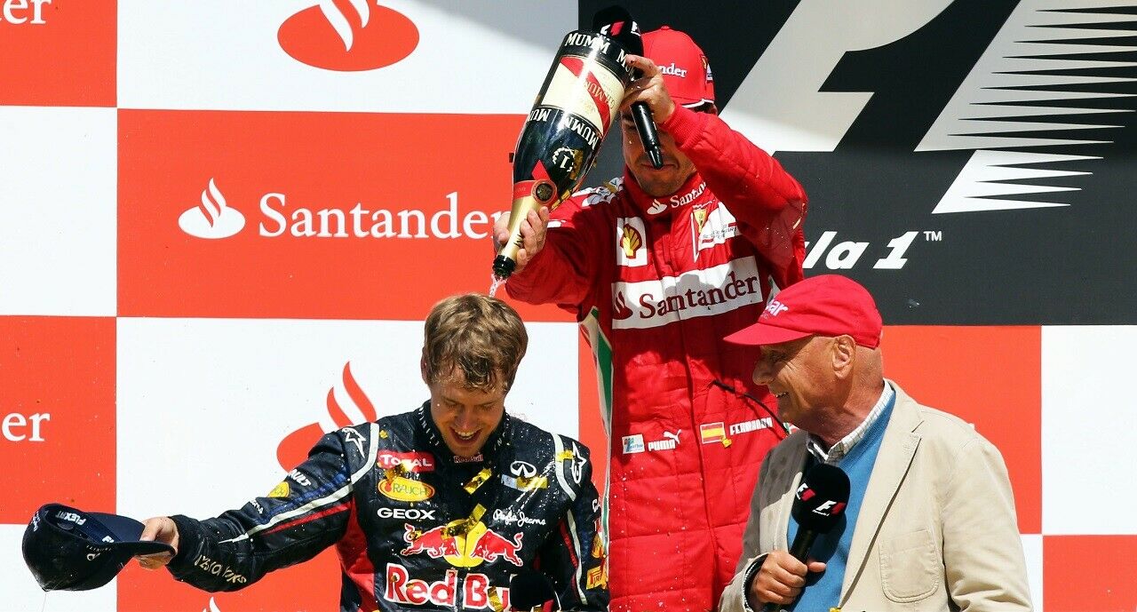 Vettel und Lauda 2012 auf dem Podium nach dem Grand Prix von Hockenheim, während Alonso den Champagner "verteilt"