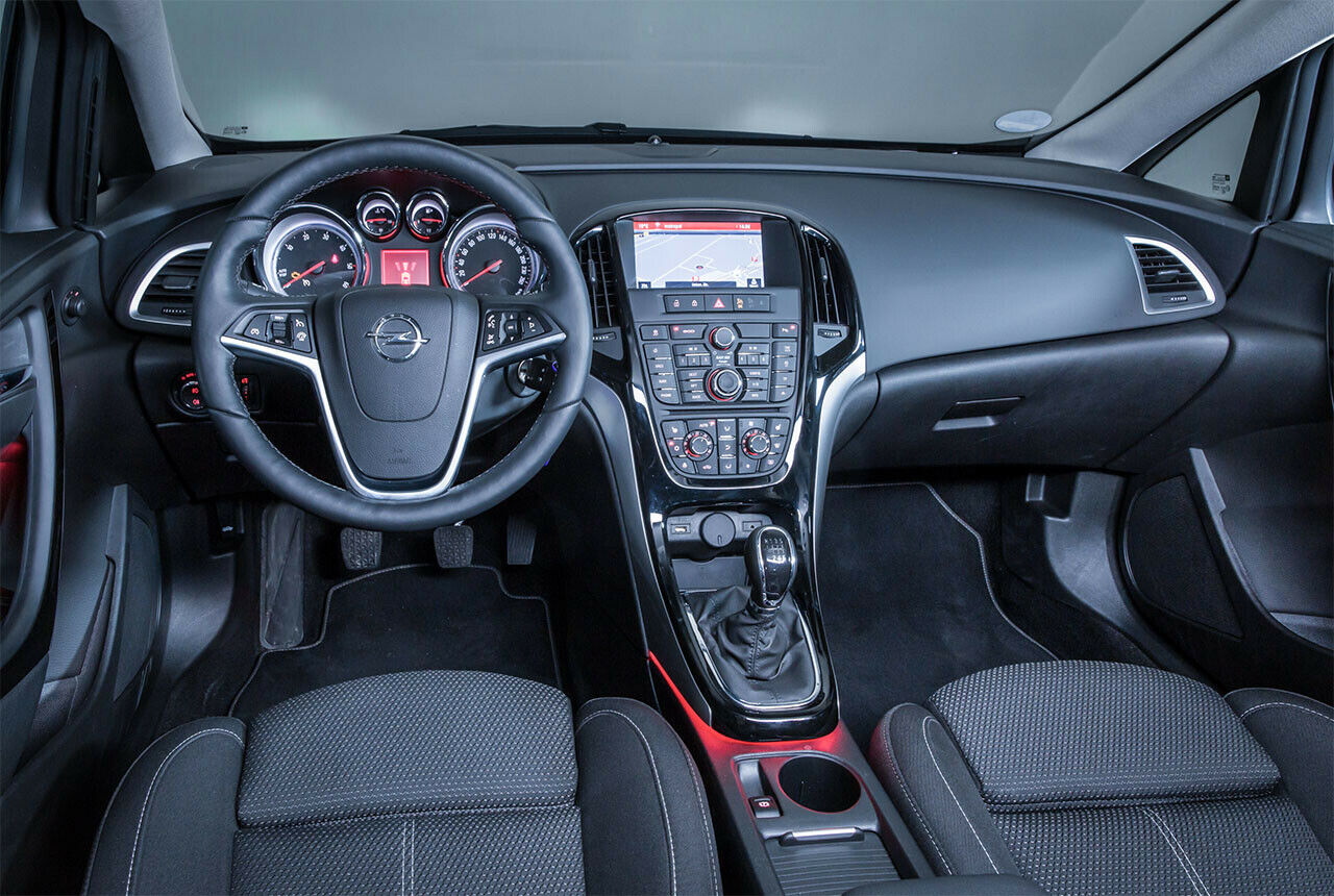 Cockpit des Opel Astra J Kombi: Das schicke, rote Ambientelicht täuscht nicht über die vielen Knöpfe und die verbaute A-Säule hinweg