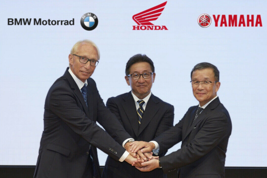 Von Links: Prof. Dr. Karl Viktor Schaller (BMW), Tetsuo Suzuki (Honda) u. Takaaki Kimura (Yamaha) besiegeln ihr künftige Zusammenarbeit mit einem Handschlag