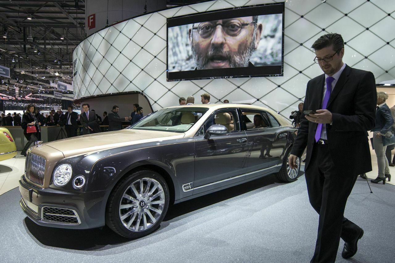 International: Bentleys Luxuslimousine Mulsanne (UK) parkt in Genf (CH) unter einem Bildschirm, auf dem Bentley-Testimonial Jean Reno (FR) zu sehen ist