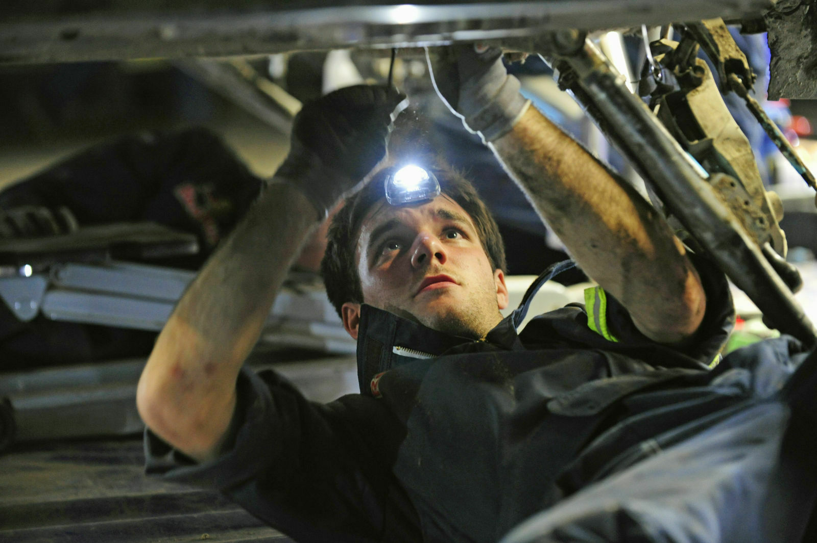 Die Mechaniker arbeiten auf dem Rücken liegend - ohne Rollbrett