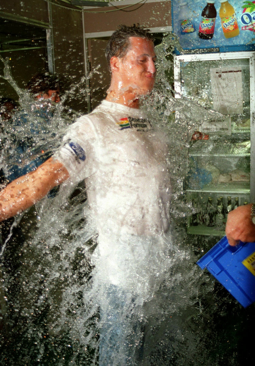 Eine Wasserdusche für Schumi: In der Benetton-Box wurde nach dem Titelgewinn kräftig gefeiert