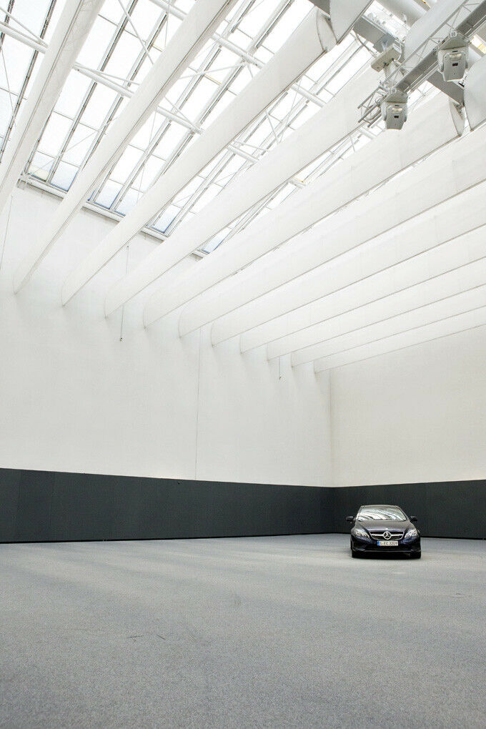 An der Decke der Präsentationshalle hängen verstellbare  Reflektionsschirme