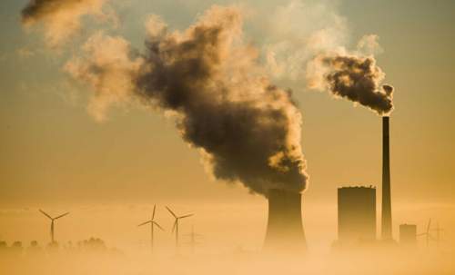 Schornsteine und Windräder: Die Energiewende ist in Arbeit. Der Autoverkehr ist nach der Energieerzeugung der zweitgrößte CO2-Produzent - und muss sich ebenfalls wandeln