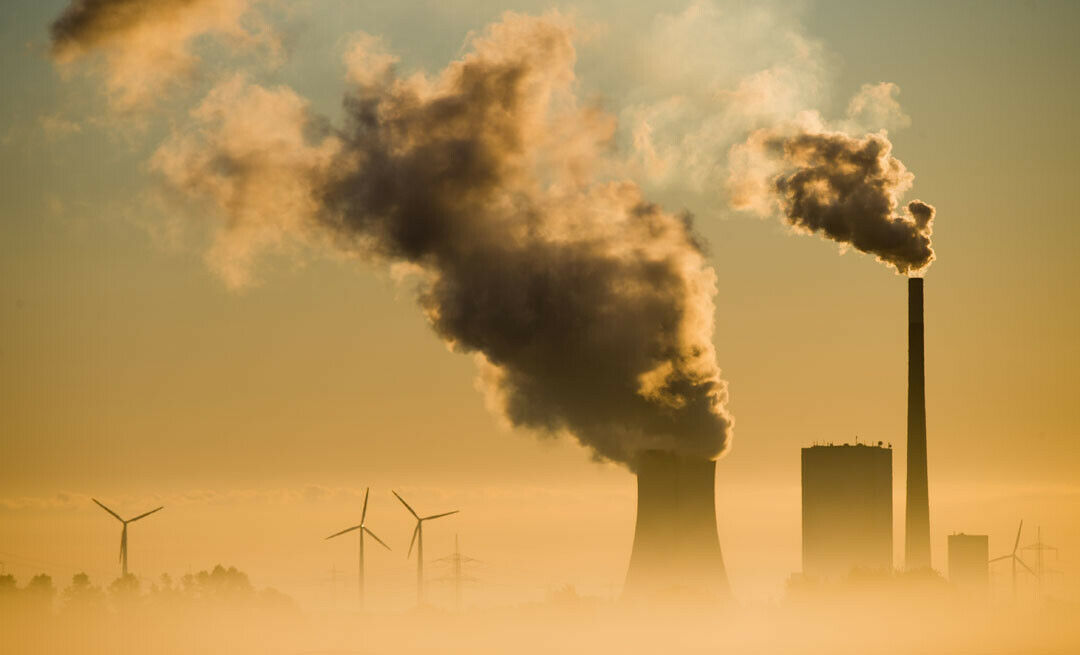 Schornsteine und Windräder: Die Energiewende ist in Arbeit. Der Autoverkehr ist nach der Energieerzeugung der zweitgrößte CO2-Produzent - und muss sich ebenfalls wandeln
